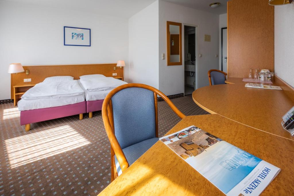 a hotel room with a bed and a table at Akzent Congresshotel Hoyerswerda in Hoyerswerda