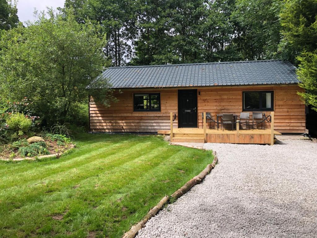 a log cabin with a patio and a yard at Willowbeck Lodge in Settle
