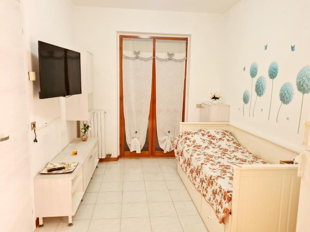 1 dormitorio con 1 cama y TV de pantalla plana en Trilocale in affitto, en Marzocca di Senigallia