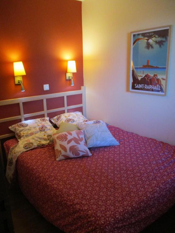 a bedroom with a bed with pillows on it at &quot;Location Vue MER et ESTEREL&quot;, Cap Estérel Agay-Saint Raphaël, T2, piscines, parking, wifi in Saint-Raphaël