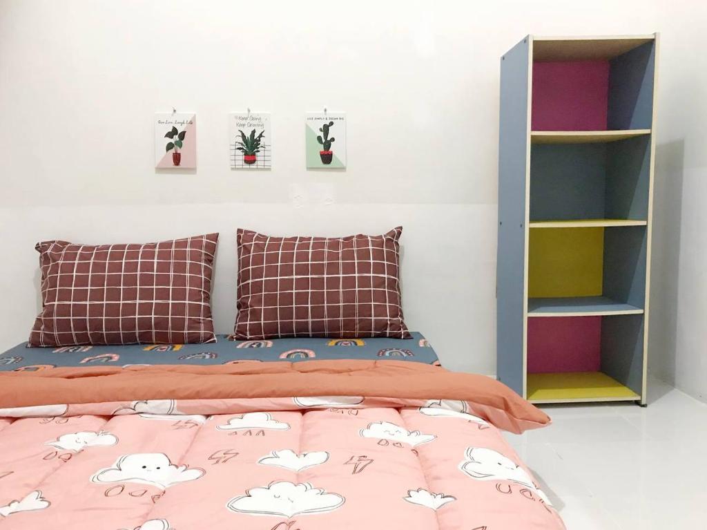 a bedroom with a bed and a book shelf at Dehome near Pakuwon Mall in Surabaya