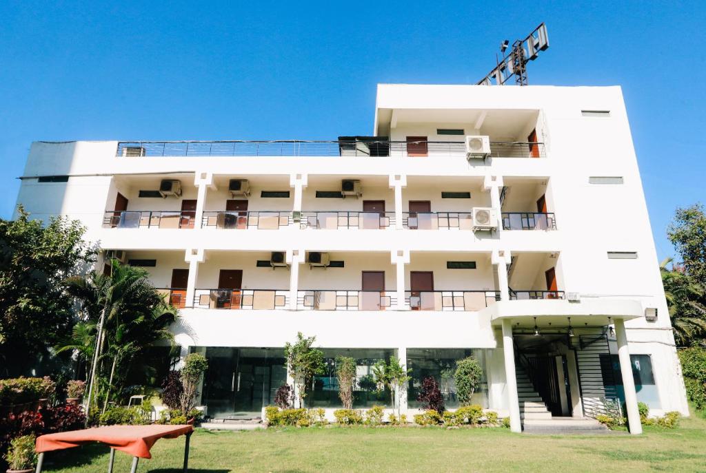 un edificio blanco con un patio delante en Hotel Shree en Indore