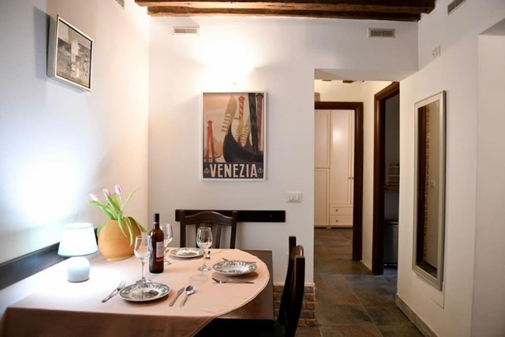 Grace Apartment in Venice في البندقية: غرفة طعام مع طاولة وغرفة طعام