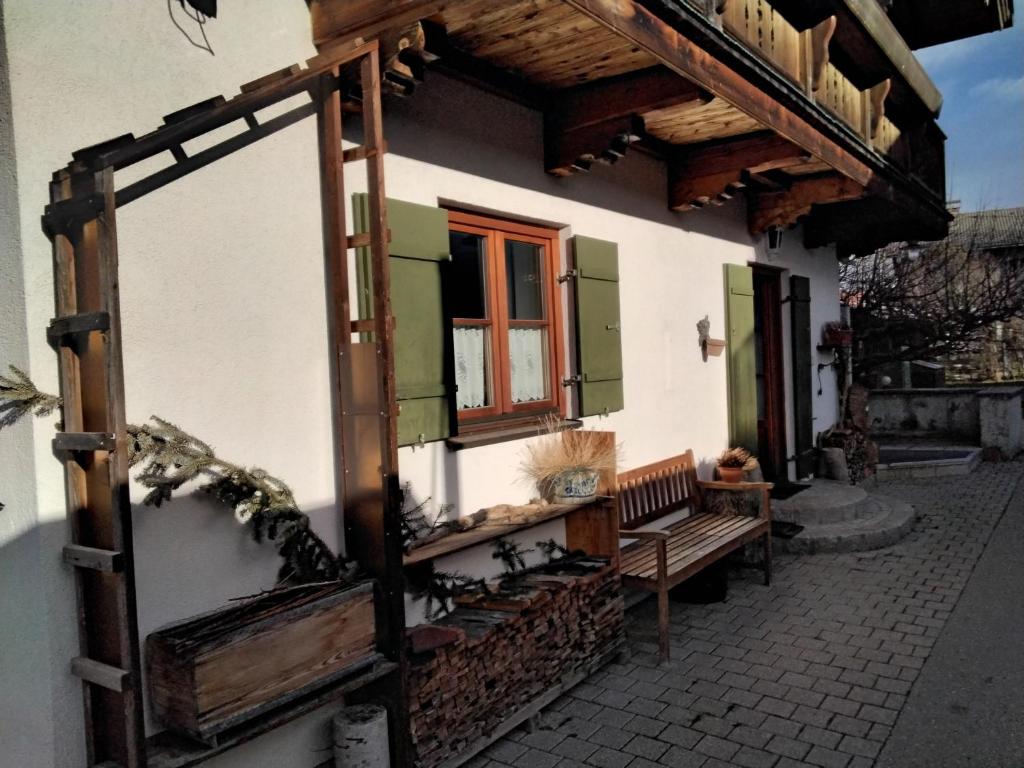 - un bâtiment avec un banc et une fenêtre dans l'établissement Ferienwohnung Maxl, à Fischbachau
