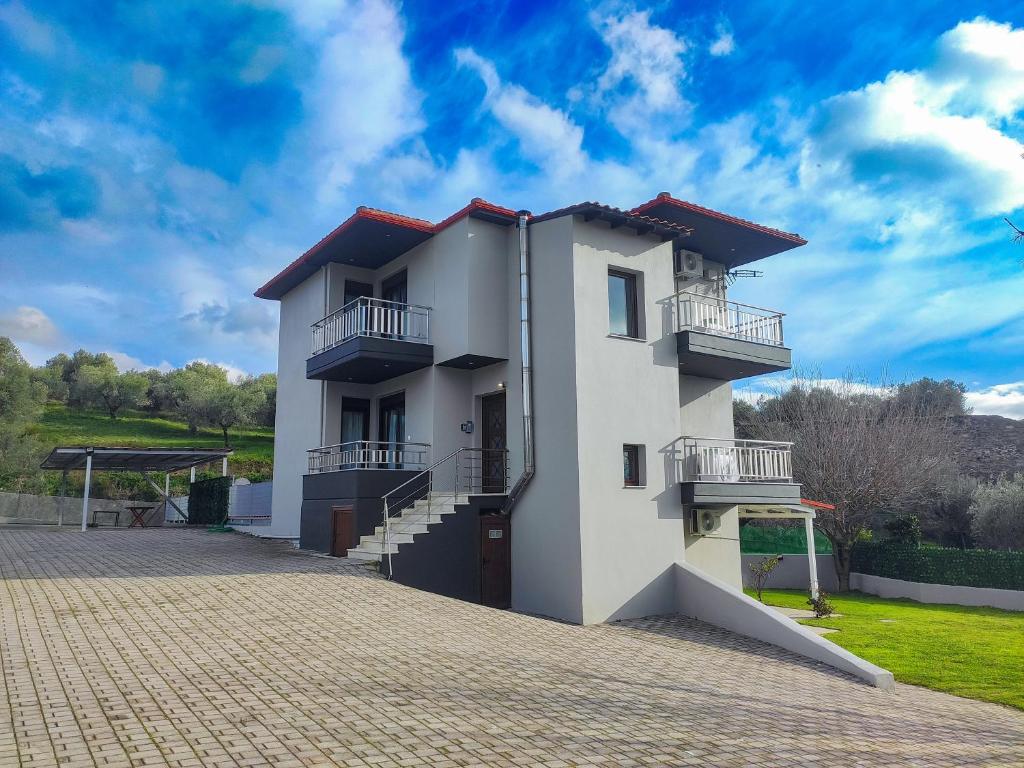 - un bâtiment blanc avec balcon et ciel bleu dans l'établissement Kashmir Luxury Apartments, à Neos Marmaras