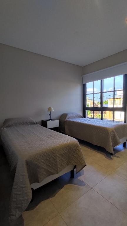 2 camas en una habitación con ventana grande en Complejo Turístico Miguel Cané en San Rafael