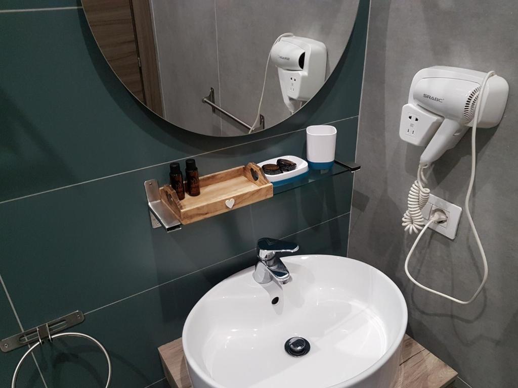 een badkamer met een witte wastafel en een spiegel bij Your Home in Naples in Napels