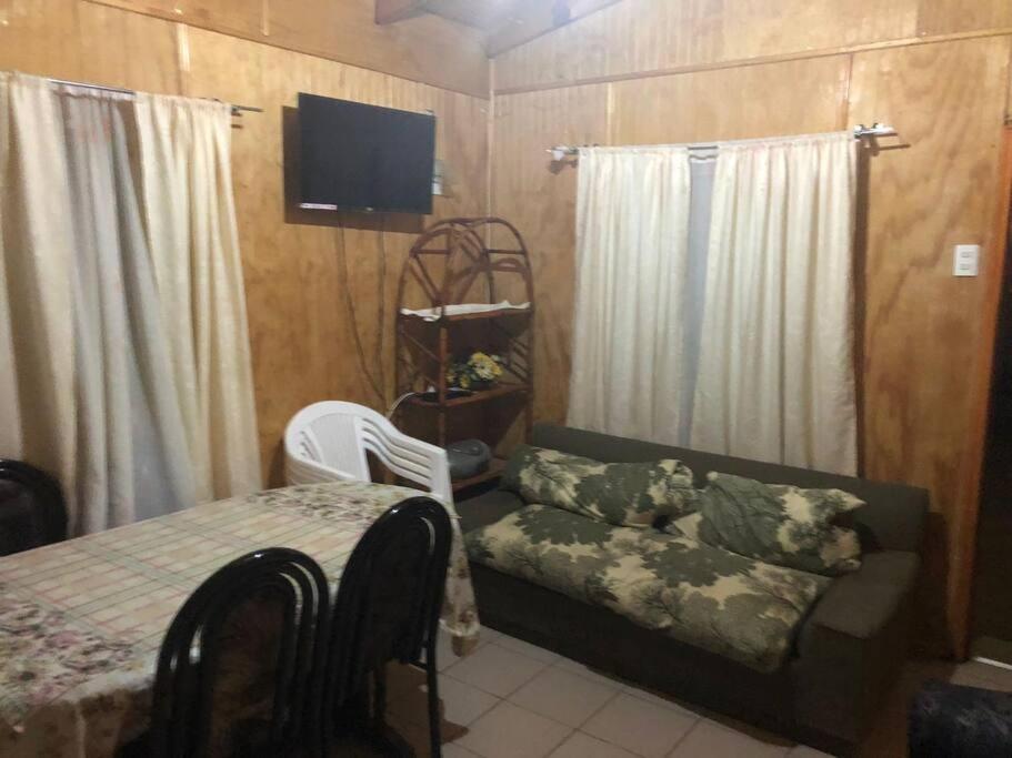 ein Wohnzimmer mit einem Sofa, einem Bett und einem TV in der Unterkunft Cabañas Pino, Un lindo lugar de descanso -playa I in Las Cruces