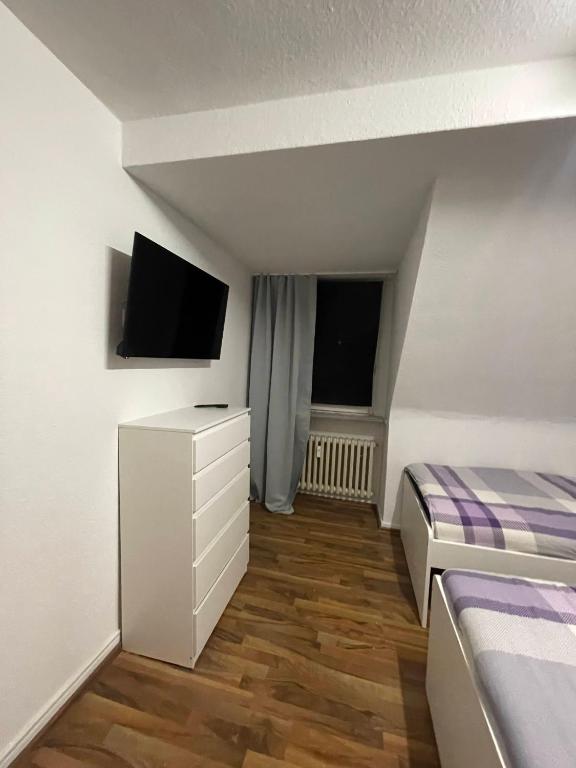 una piccola camera con letto e TV di Monteur Wohnung für 4 Personen in Oberhausen. a Oberhausen