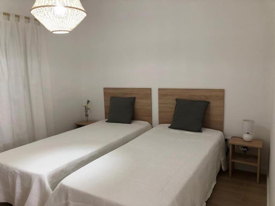 two beds sitting next to each other in a bedroom at Apartamento T2 Montegordo a 500 m da praia in Monte Gordo
