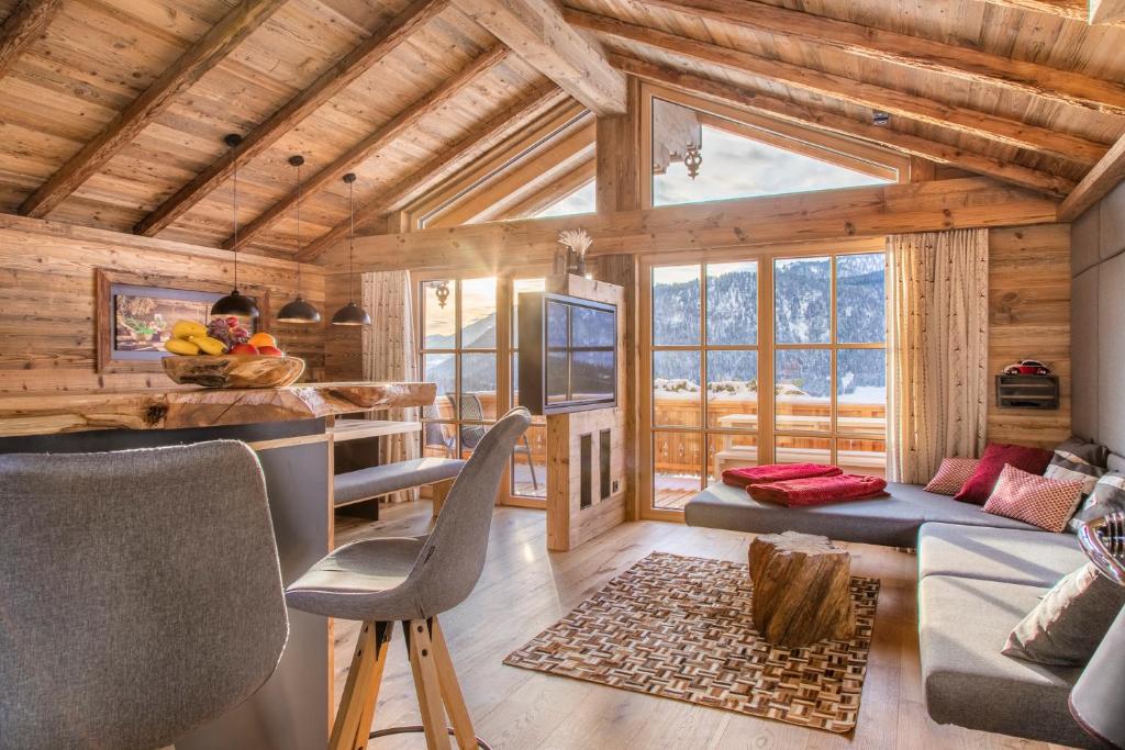 ein Wohnzimmer mit einem Blockhaus und einem großen Fenster in der Unterkunft Chalet Schintlbauer in Annaberg im Lammertal