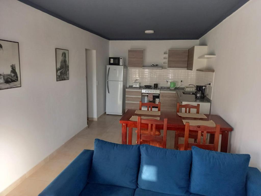 sala de estar con sofá azul y cocina en Moderno y cómodo PH zona Aldrey/Materno en Mar del Plata