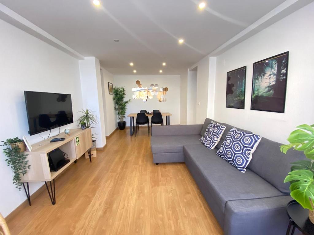 a living room with a couch and a flat screen tv at Central Station Apartment in Setúbal