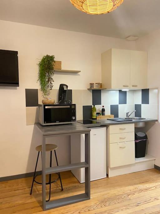 a kitchen with a table with a microwave on it at Studio Coquet proche Gare in Bourg-en-Bresse
