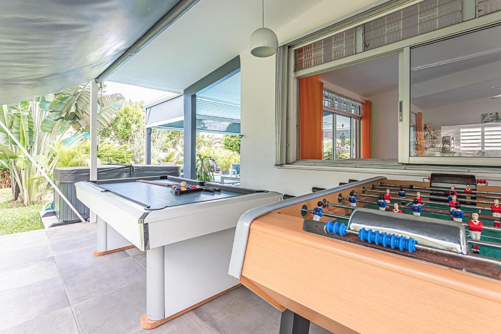 a room with a pool table and two billards at Villa de 3 chambres avec piscine privee jacuzzi et jardin clos a Baie Mahault in Baie-Mahault