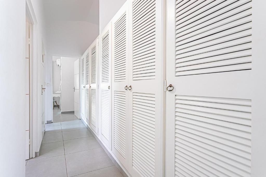 a hallway with white wooden closet doors in a house at Villa de 3 chambres avec piscine privee jacuzzi et jardin clos a Baie Mahault in Baie-Mahault