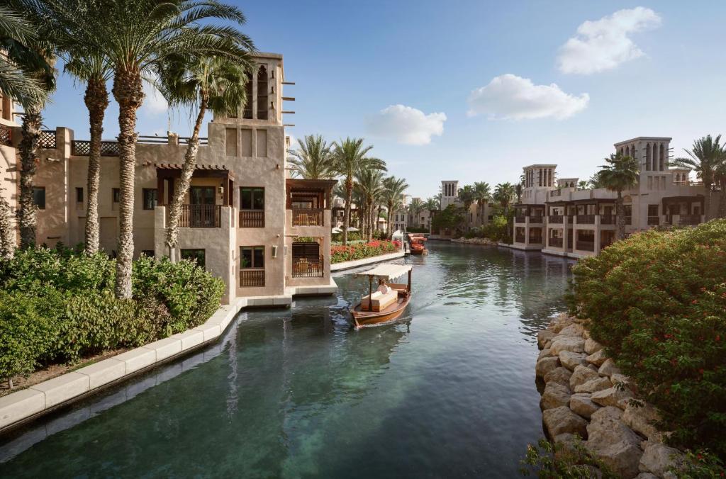 ドバイにあるJumeirah Dar Al Masyaf Dubaiの椰子の木が茂る街の船の運河