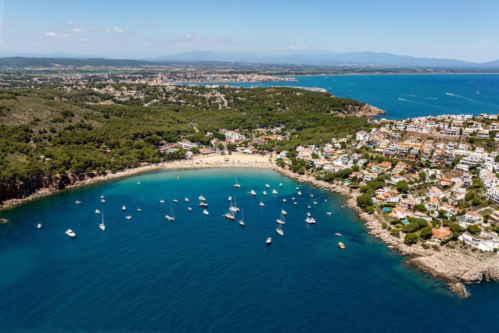 una vista aérea de una playa con barcos en el agua en wecamp Cala Montgó, en L'Escala