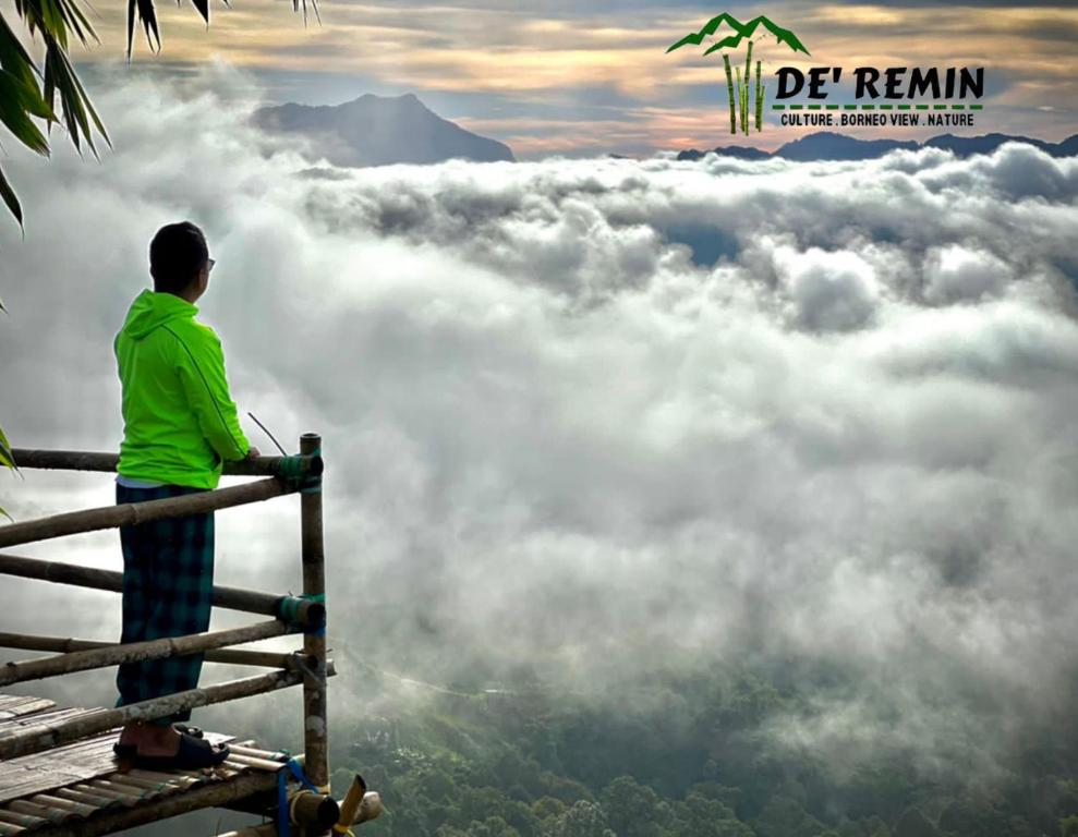 Człowiek stojący na szynie patrzący na chmury w obiekcie De'Remin Sapit w mieście Kuching