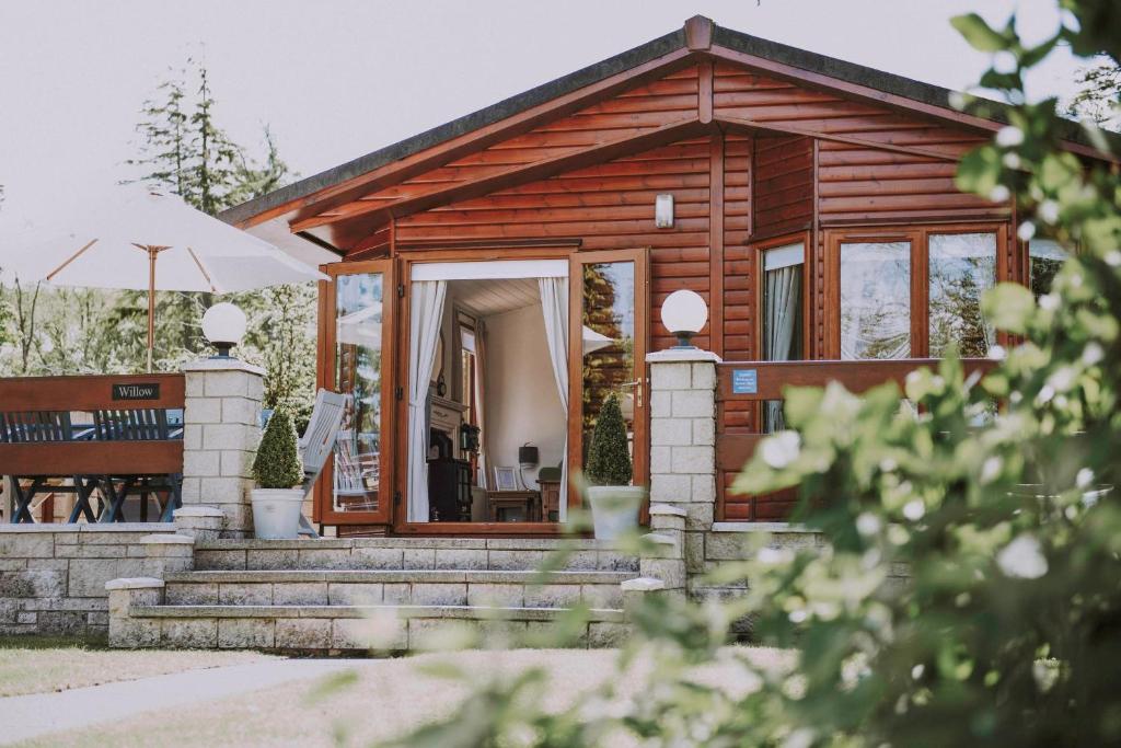 a log cabin with a staircase leading to the front door at Walled Garden Lodges Loch Lomond in Balloch