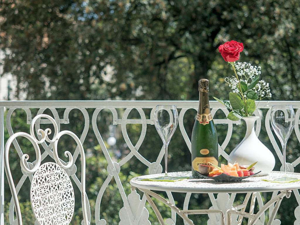 uma mesa com uma garrafa de champanhe e uma rosa em Residenza Viani Guest House em La Spezia