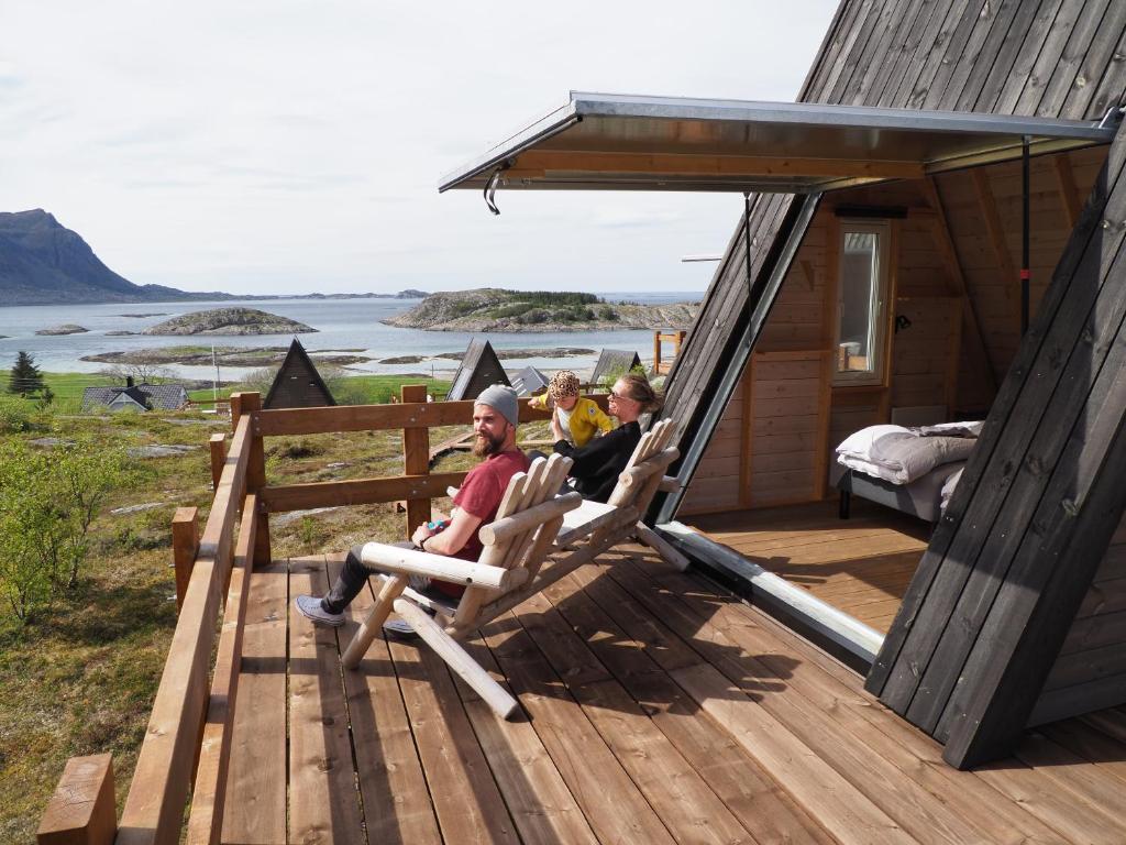 un grupo de personas sentadas en sillas en la cubierta de una casa en BaseCamp Vega, en Sundsvoll