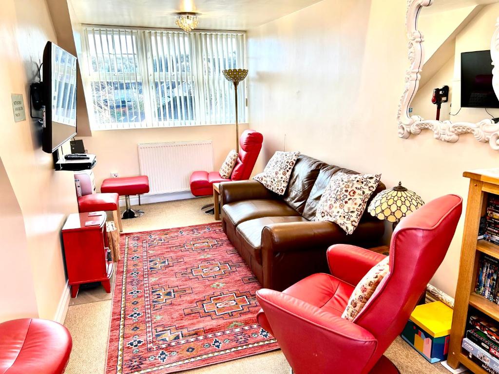 a living room with a couch and chairs and a mirror at The Upper Bakery in Cromer