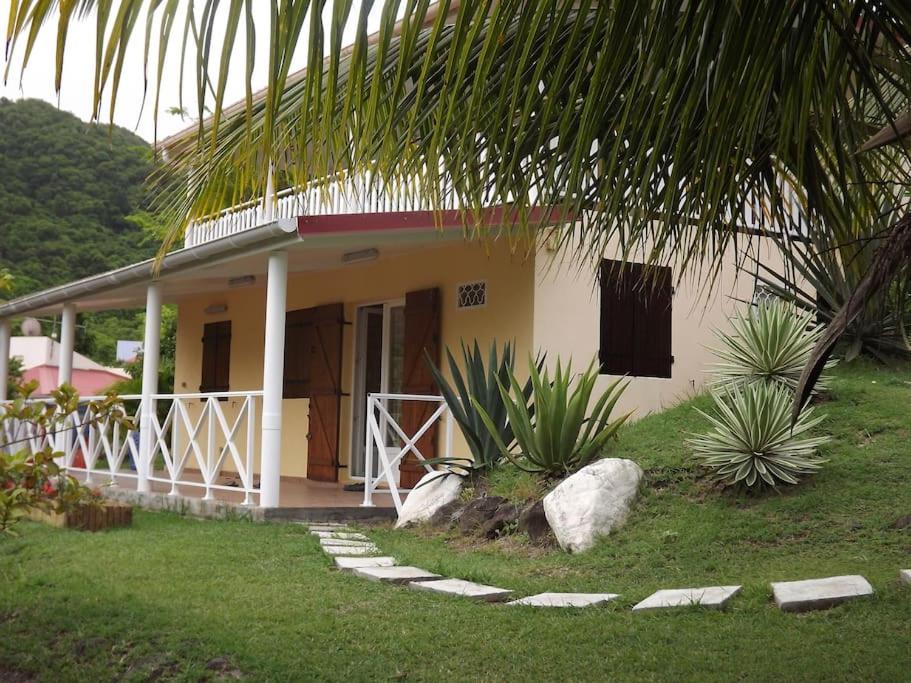 una casa con un porche y algunas plantas delante de ella en Studio proche mer & climatisé les Anses d'Arlet en Les Anses-dʼArlets