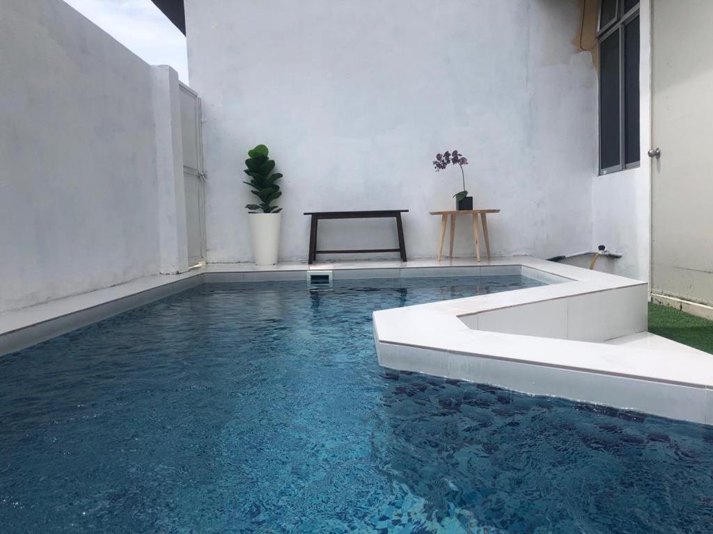 uma piscina com água azul num quarto em Lungo Guesthouse em Kuala Terengganu