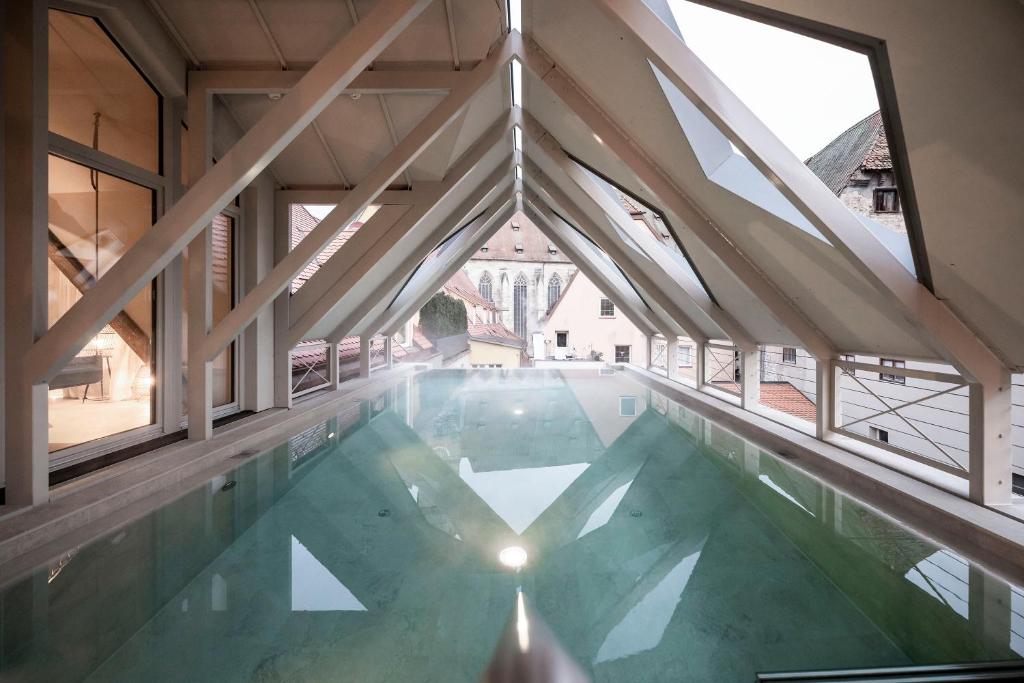 a swimming pool in a building with large windows at HOTEL & SPA Goldene Rose in Dinkelsbühl