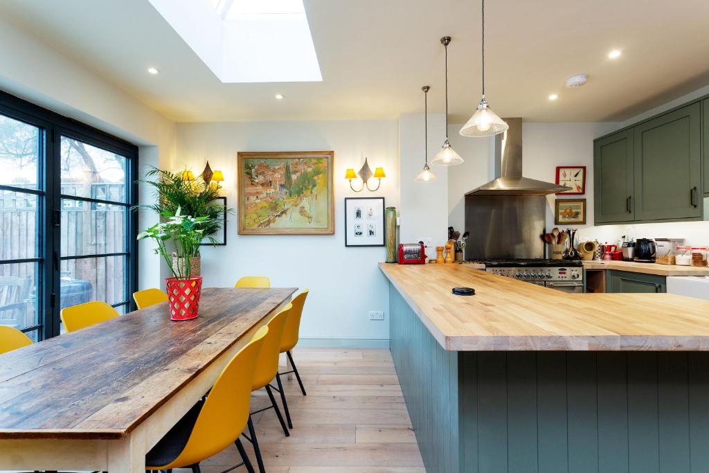 una cucina con tavolo in legno e sedie gialle di Veeve - Family Favourite a Londra