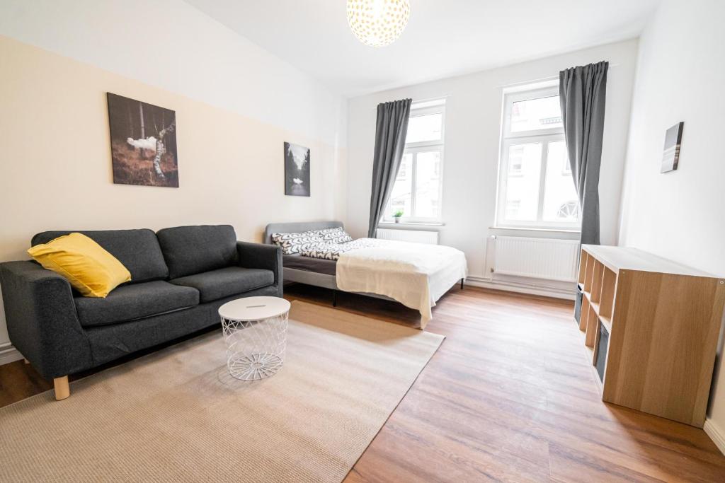 a living room with a couch and a bed at FULL HOUSE 3 Bedroom Apartment Halle NH14 in Halle an der Saale