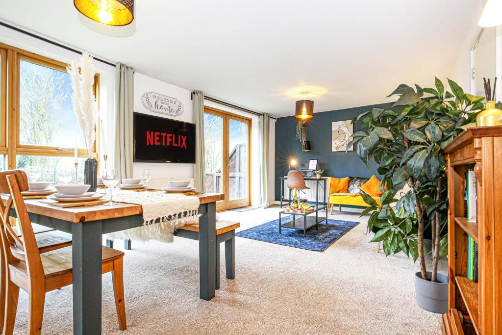 Beautiful City Centre Apartment with Free Parking, Fast-Wifi, SmartTV with Netflix and Private Garden by Yoko Property في ميلتون كينز: غرفة معيشة مع طاولة وغرفة طعام