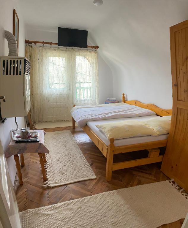 a bedroom with two beds and a television on the wall at Pensiunea Panorama in Băile Tuşnad