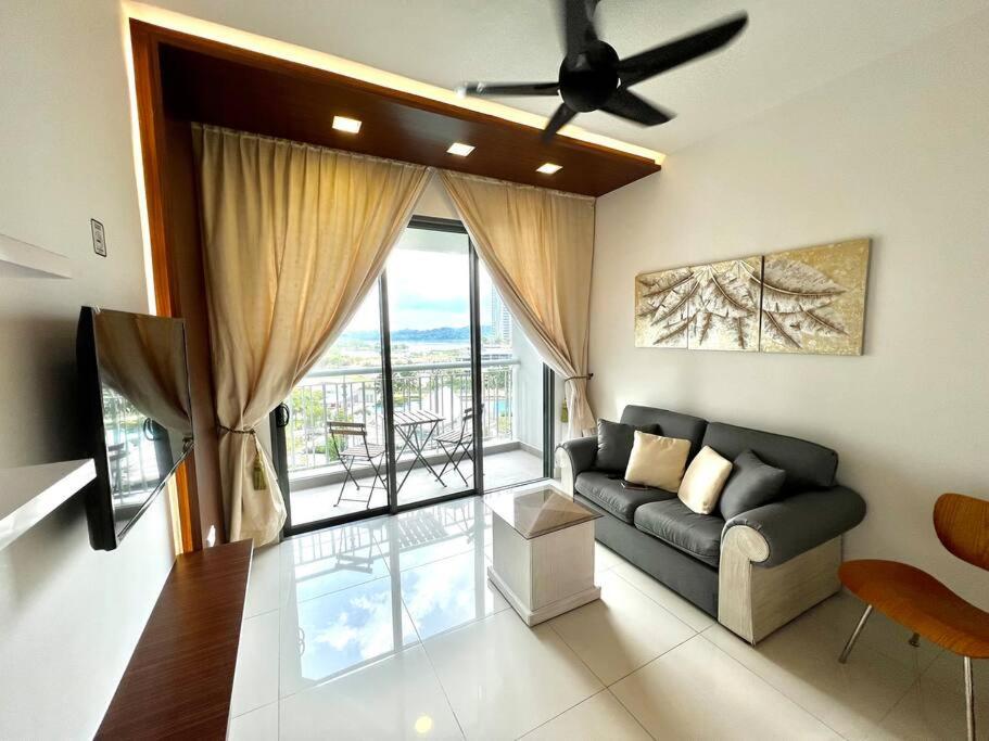 Teega Suites Puteri Harbour Iskandar Puteri #PoolView SeaView في نوساجايا: غرفة معيشة مع أريكة ونافذة كبيرة