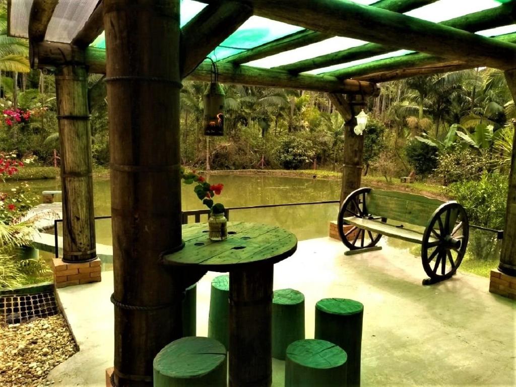 une table et un banc dans un pavillon dans l'établissement Sitio Libardo em Meio a Natureza - Nova Trento, à Nova Trento