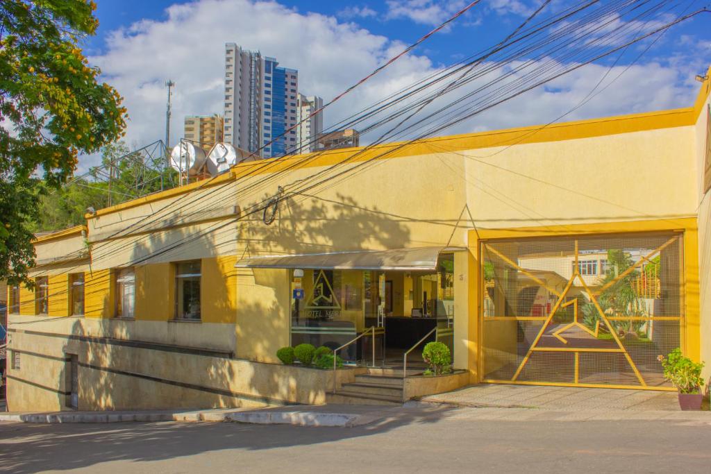 a yellow building in front of a building at Hotel Meri in Conselheiro Lafaiete