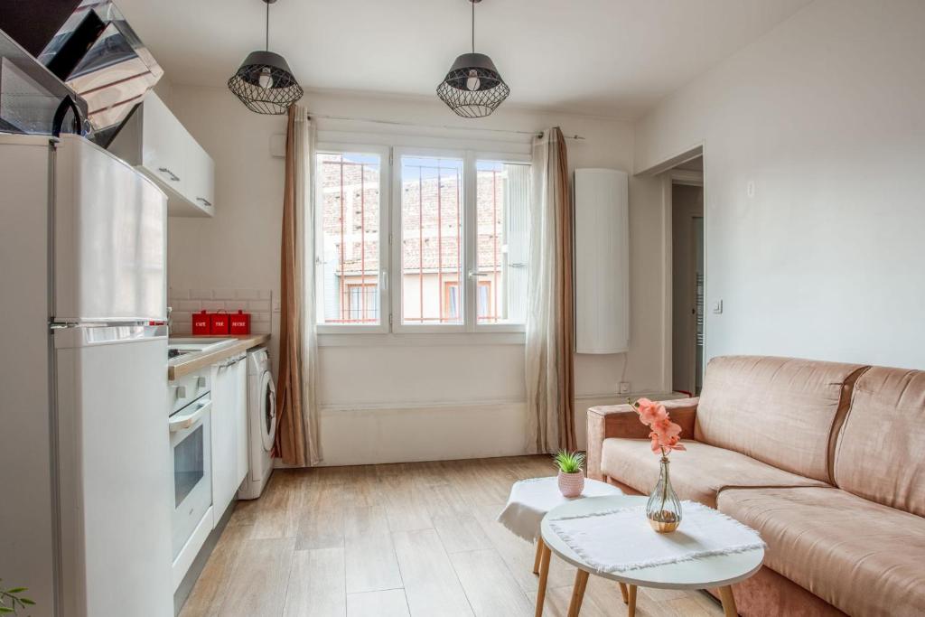 un salon avec un canapé et une table dans l'établissement Appartement Ocre - Welkeys, à Bagnolet