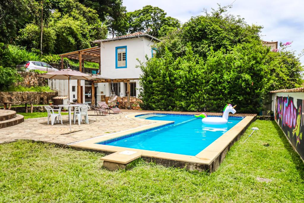 a swimming pool with a swan in a yard at Del Mundo Hostel in São João del Rei