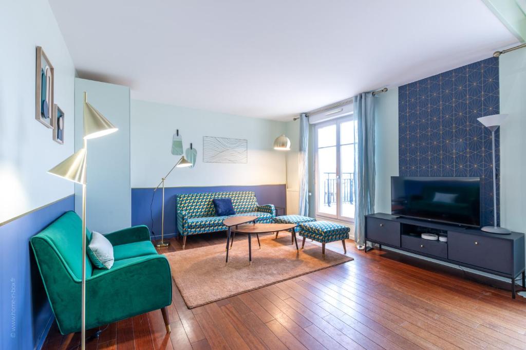 - un salon avec un canapé vert et une télévision dans l'établissement Duplex Chancelier - Fairytale Factory, à Bussy-Saint-Georges