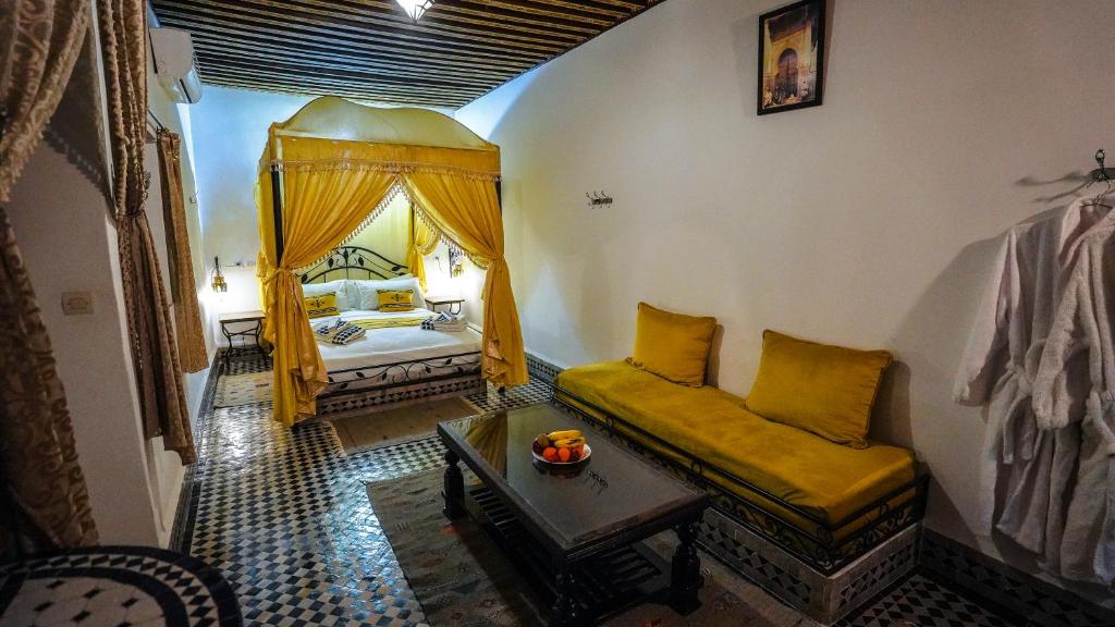 a living room with a couch and a bed at Riad Green House in Fès