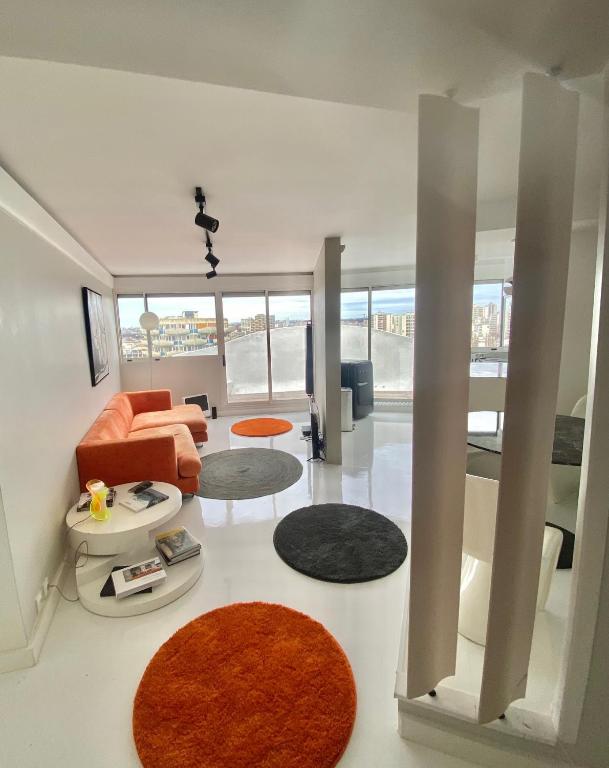 - un salon avec un canapé orange et un tapis dans l'établissement 14eme et der étage 