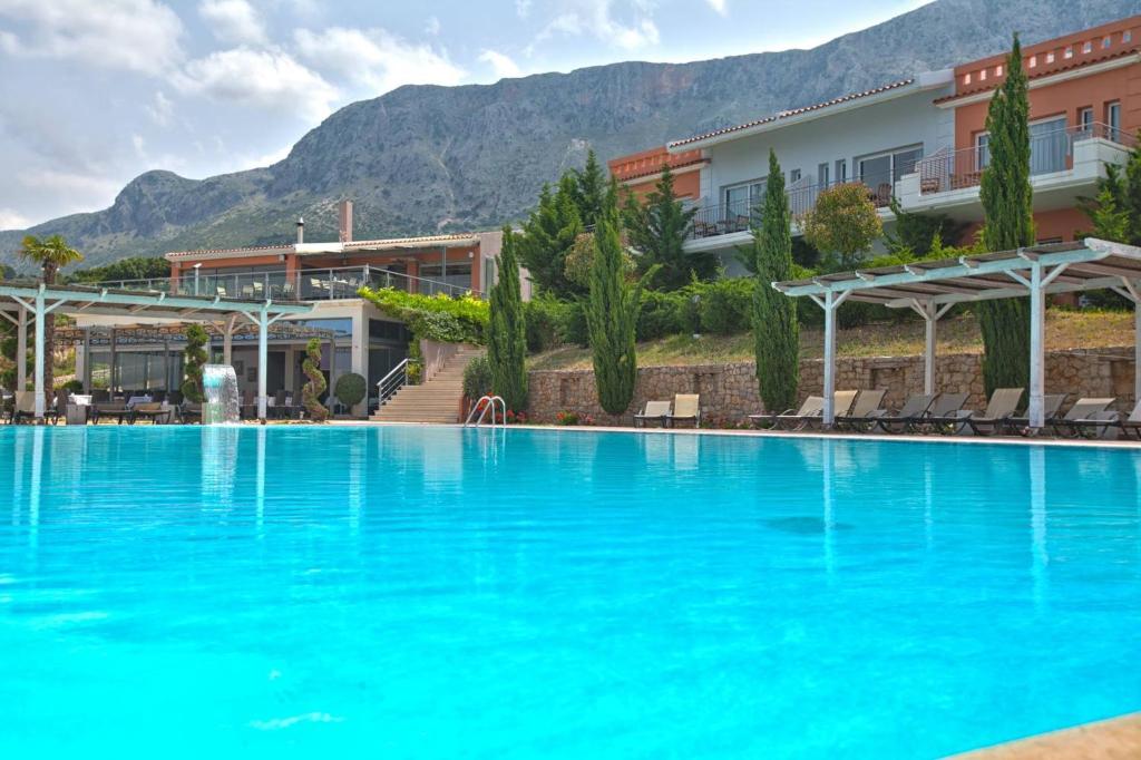 einem großen blauen Pool vor einem Gebäude in der Unterkunft Thalassa Hotel in Palairos