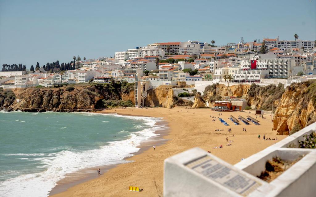 a view of a beach with people and buildings at Aquamar Albufeira Aparthotel in Albufeira