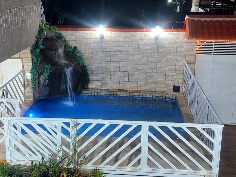 a fountain in a building with a waterfall at Hostel Falcão-Suites Privativas com Ar Condicionado in Rio das Ostras