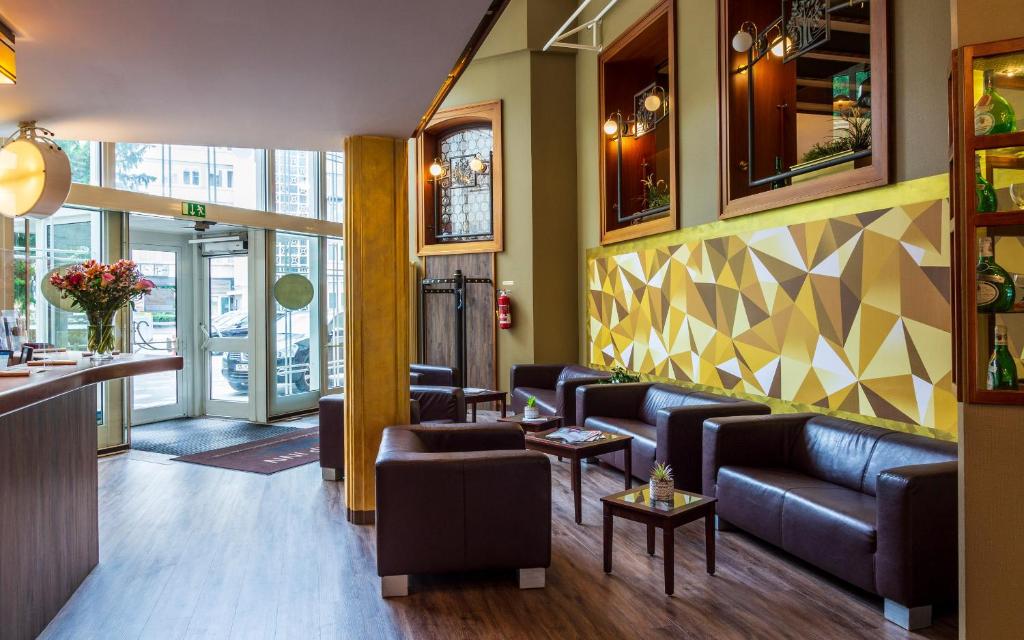 - une salle d'attente avec des canapés et un bar dans l'établissement Trip Inn Aschaffenburger Hof, à Aschaffenbourg