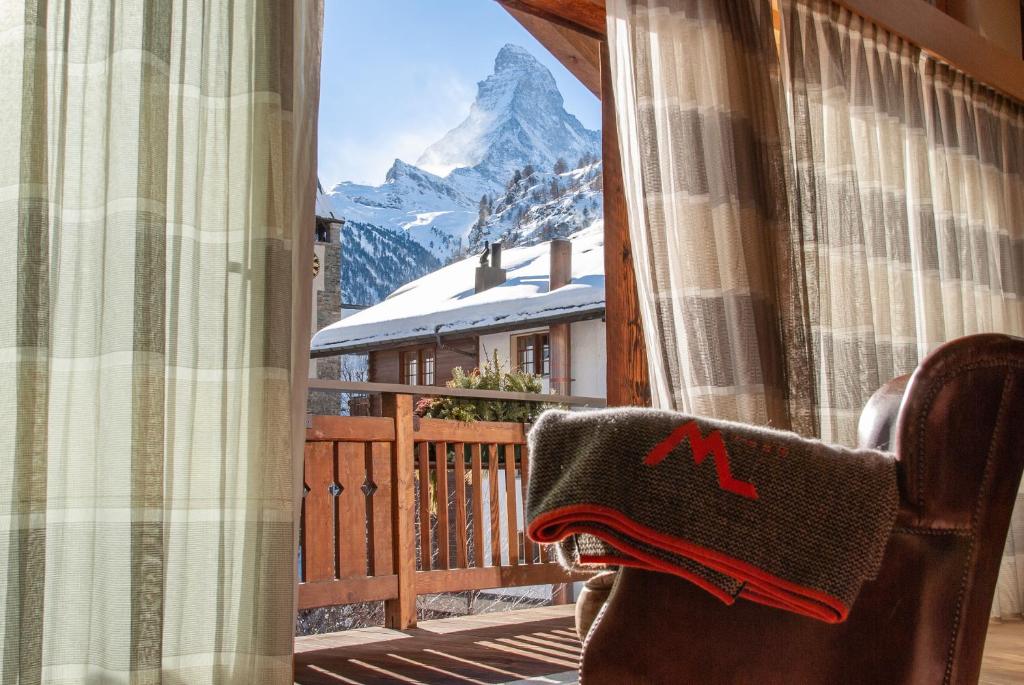 a window with a view of a mountain at Matterhorn Lodge Boutique Hotel & Apartments in Zermatt