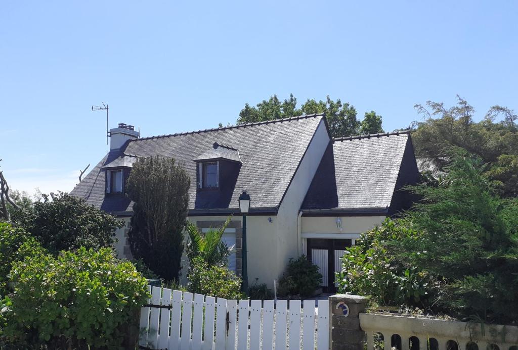 ein Haus mit einem weißen Zaun davor in der Unterkunft Chez Kat Location Ile de Groix in Groix