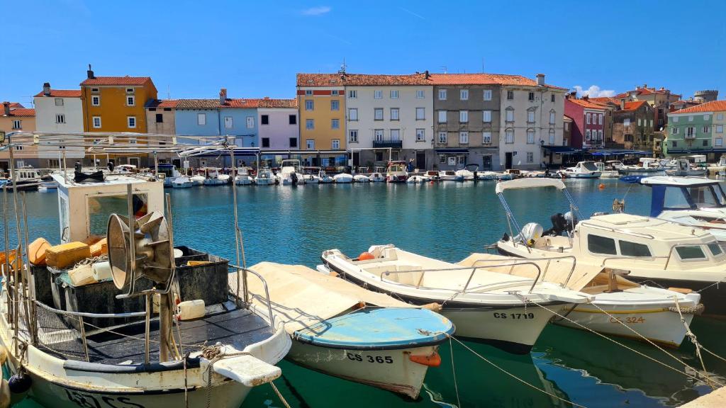 a group of boats docked in a harbor with buildings at Amorino Cres - Old Town House in Cres