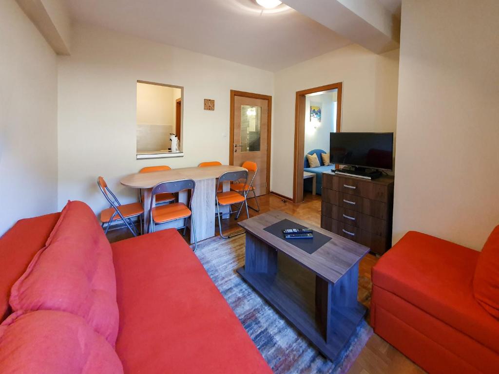 - un salon avec un canapé rouge et une table dans l'établissement Apartman Cvejic - Suncani apartmani, à Brzeće